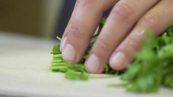 Fresh greens salad, parsley and dill on the table in the kitchen. video