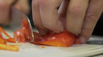mãos masculinas páprica de pimentão orgânico de corte limpo. close-up das mãos de um cozinheiro masculino cortando páprica fresca com uma faca video