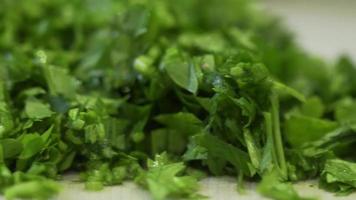 frischer grüner salat, petersilie und dill auf dem tisch in der küche. video