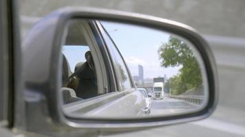 Reflections in the side mirror of a car on highway video