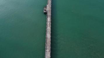 vista aérea de um drone de um cais em um mar tropical. muitos barcos de pesca tradicionais tailandeses de cauda longa no mar. video