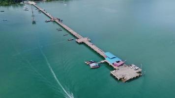 Aerial view from a drone of a pier in a tropical sea. A lot of Thai traditional longtail fishing boats in the sea. video