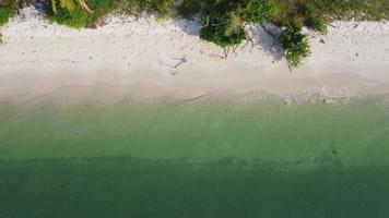 hermosas olas del mar y playa de arena blanca en la isla tropical. suaves olas de océano azul en el fondo de la playa de arena desde la vista superior de los drones. concepto de relajación y viajes de vacaciones.