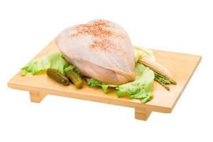 Chicken breast on wooden board and white background photo