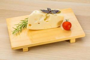 Maasdam cheese on wooden background photo