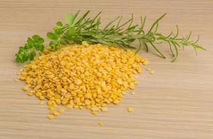 Raw yellow lentils on wooden background photo