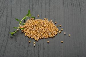 Mustard seeds on wooden background photo