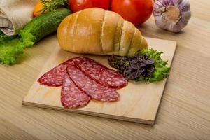 Salami on wooden plate photo