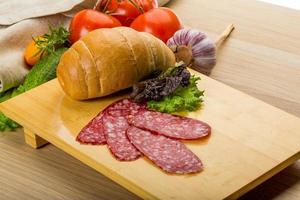 Salami on wooden plate photo