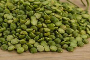 Dry green peas on wooden background photo