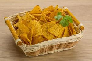 Nachos in a basket on wooden background photo