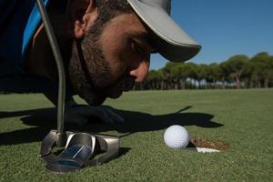 golf player blowing ball in hole photo