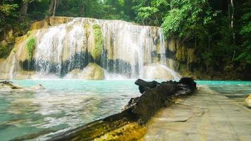 Natural scenery of beautiful Erawan waterfalls in a tropical rainforest environment and clear emerald water.