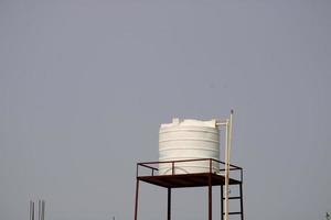 tanque de agua de plástico en la parte superior de la casa de un pueblo indio. foto