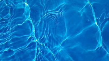 desenfoque borroso transparente color azul claro agua tranquila textura superficial con salpicaduras y burbujas. fondo de naturaleza abstracta de moda. ondas de agua a la luz del sol. fondo de agua azul. agua brillando video