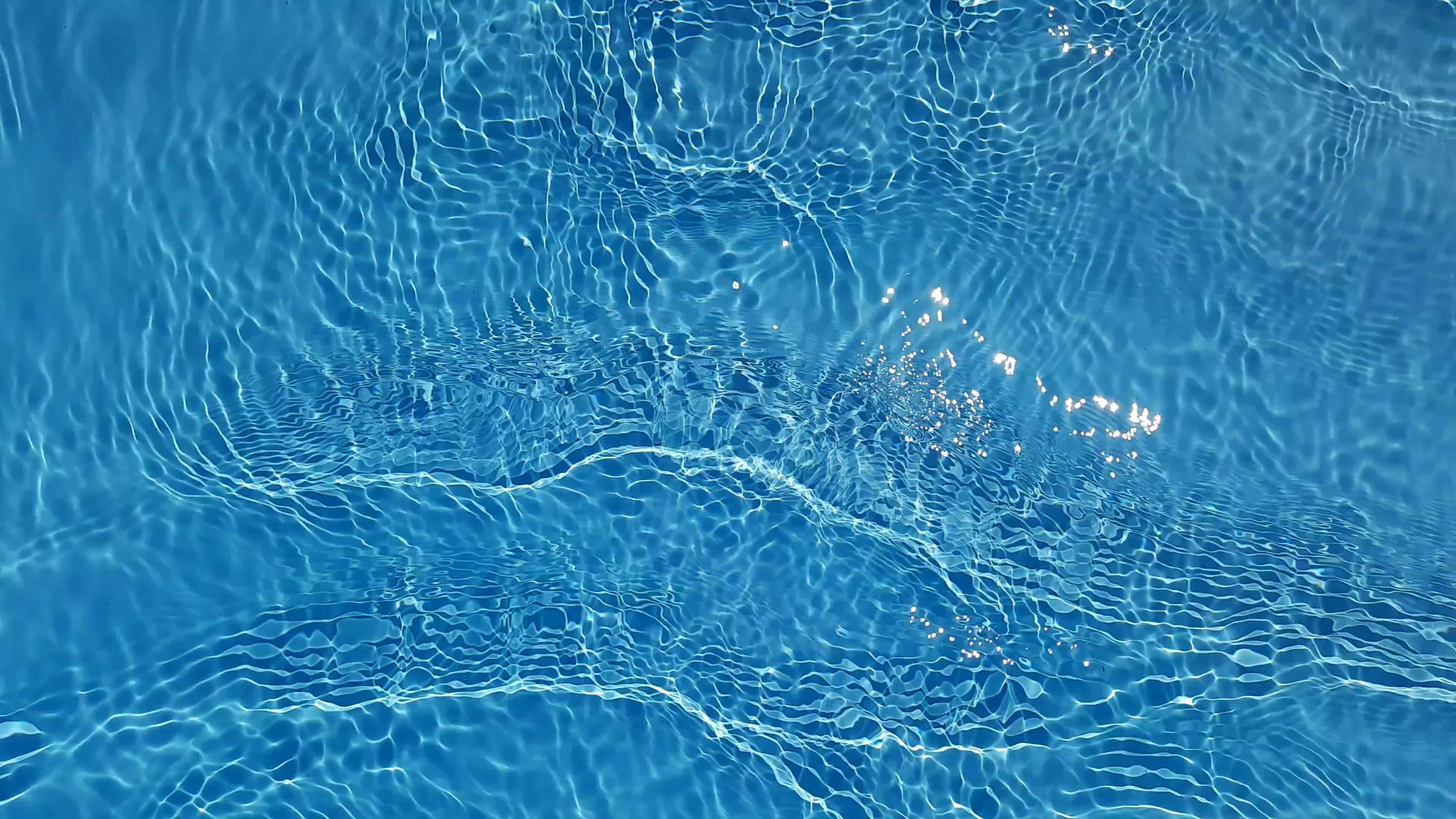 Defocus blurred transparent blue colored clear calm water surface