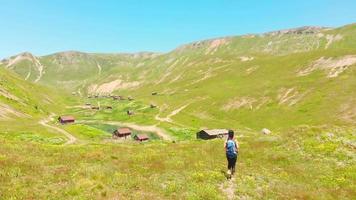 excursionista caucásico en montañas escénicas disfruta del impresionante panorama del pueblo de shuamta. feliz viaje inspirador aventura video
