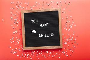 Letter board with hearts on red background. Top view. Background for Valentine's day photo