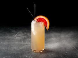 Cold alcoholic or non-alcoholic cocktail with ice on dark background photo