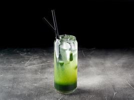 Cold alcoholic or non-alcoholic cocktail with ice on dark background photo