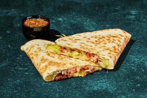 Quesadilla with chicken, cheese, vegetables and herbs and sauce photo