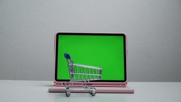 stop motion a cart shopping moving around tablet green screen. video