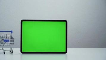 stop motion een winkelwagentje dat beweegt rond tablet groen scherm. video