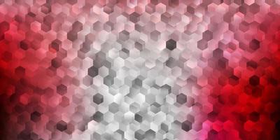 Light pink, red vector backdrop with a batch of hexagons.