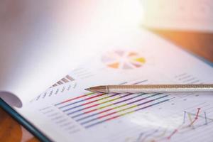 pluma en diagramas gráficos documento de papel de gráfico de negocios trabajando en la oficina - concepto de plan de informe de negocios foto