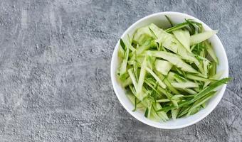 Cucumber slice on white bowl , top view - shredded cucumber sliced for salad or cooking food photo