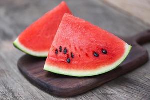 Sliced watermelon on wooden cutting board background Close up fresh watermelon pieces tropical summer fruit photo