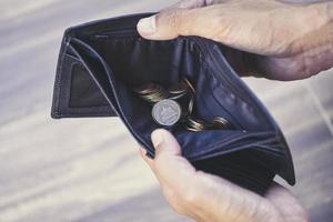 Moneda en concepto de billetera y gestión de deuda - billetera vacía en manos de un anciano pobreza en concepto de jubilación foto