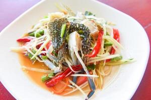 Papaya salad with blue crab - Thai food raw crab spicy salad seafood and vegetable photo