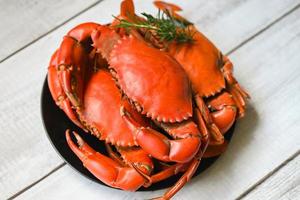 seafood plate with herbs spices rosemary, fresh crab on black plate, crab cooking food boiled or steamed crab red in the restaurant photo