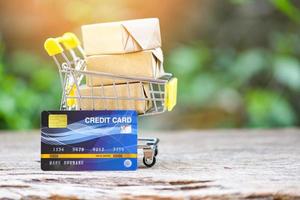 Online payment credit card and parcel boxes in shopping cart - shopping online technology and credit card payment concept photo