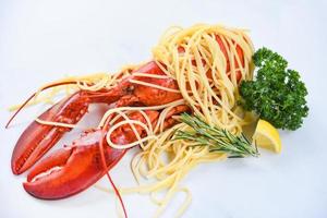 Spaghetti seafood lobster food on a white plate with herb spices lemon rosemary served table in the restaurant gourmet food healthy boiled lobster cooked salad spaghetti shrimp photo