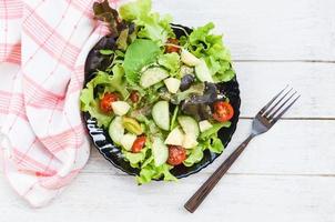 ensalada ensalada de verduras con fruta y lechuga fresca tomate pepino en un plato en la mesa concepto de alimentación saludable foto