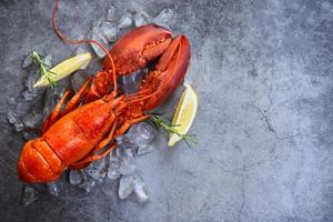 Fresh lobster food on a black plate background - red lobster dinner seafood with herb spices lemon rosemary served table and ice in the restaurant gourmet food healthy boiled lobster cooked photo