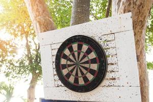 viejo dardo golpeó la marca en el tablero de dardos en el árbol foto