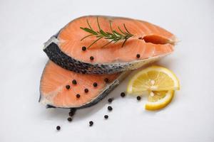 Fresh salmon steak on white plate  background - Raw salmon fish fillet for cooked steak seafood with herbs and spices lemon rosemary photo