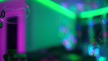 las burbujas flotan en una habitación oscura con luces multicolores