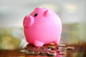 Money coin and pink piggy bank at table at home close up - save money for scholarships concept photo