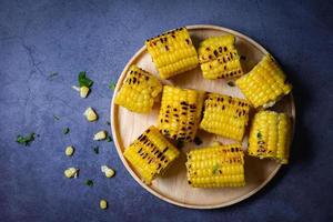 corn food , sweet corn cooked on black background, ripe corn cobs grilled sweetcorn for food vegan dinner or snack photo