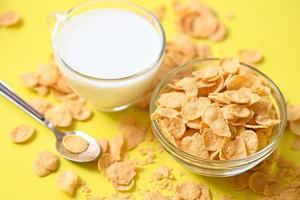 copos de maíz con leche sobre fondo oscuro, tazón de copos de maíz comida para el desayuno y merienda para un concepto de comida saludable, desayuno matutino cereal integral fresco foto