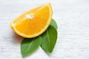 Orange fruit on wooden background - Fresh orange slice half and orange leaf healthy fruits concept photo