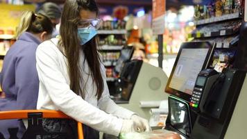 mulher fazendo compras usando máscara durante a pandemia video