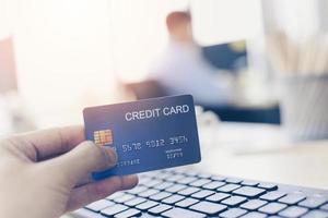 Business man holding credit card payment in a office - payment online shopping paying with credit card technology e wallet concept photo