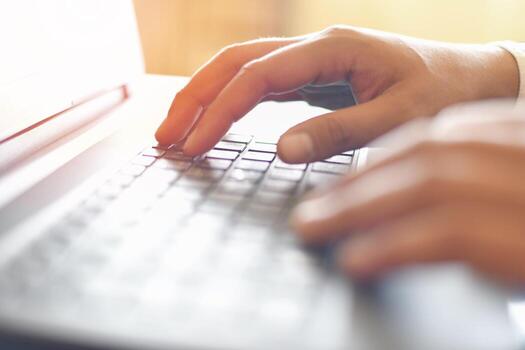 Male hand typing on keyboard concept - Businessman working on keyboard computer laptop man sitting on the table and using internet technology at workplace in office photo