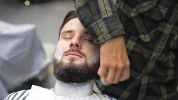 Barber lathers man's face with shaving brush video