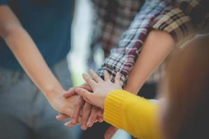 Group of business people putting their hands working together on wooden background in office. group support teamwork agreement concept. photo